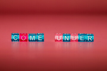 the word "come under" made up of cubes