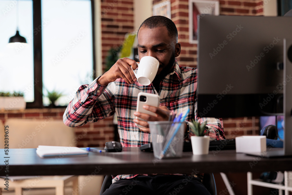 Poster modern man using social media on smartphone, working remotely at home desk. freelancer browsing inte
