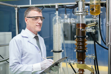 scientist in lab coat, researcher working in laboratory with cannabis oil CBD extraction machine, Chemical lab test on cannabis oil, CBD, THC, alternative medical. extract chemicals from cannabis.