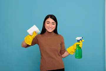 Delighted smiling and glad asian housemaid from daily routine holding spray and tissue, Cleaning home concept, Laughing cheerful and satisfied housekeeper with positive state of mind - obrazy, fototapety, plakaty