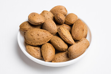 plate with almonds isolated on white