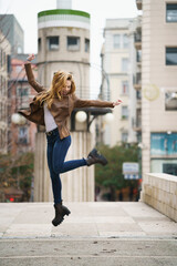 Fototapeta na wymiar Woman jumping outdoors happily alone