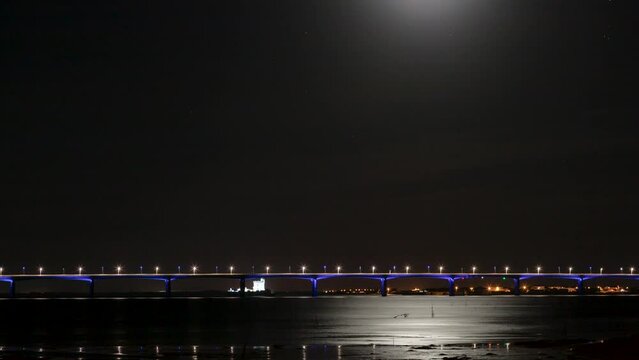 Night time lapse shot of the moon rising above the road bridge Viaduc d&rsquo;Ol&eacute;ron to the island Oleron with fortress Fort Louvois in background
