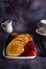 Pancakes with fruits, berries, chocolate sauce and coconut chips