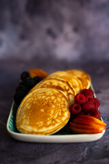Pancakes with fruits, berries, chocolate sauce and coconut chips