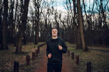 Fototapeta premium Young redhead man running in forest