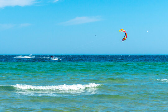 Kite surfer in the distance on turquoise waters of Baltic sea. Hel, Poland, Europe. Sport and recreation by the sea. Summer holiday.
