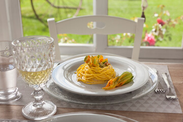 lunch set table in a bay window with zucchini floers spaghetti