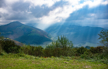 Cloudy sky and rays of light falling on the mountains of the valleys of Pas in Vega de Pas (Cantabria-Spain)