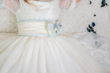 Fototapeta na wymiar dress and outfit for holy Communion girl blue flower belt