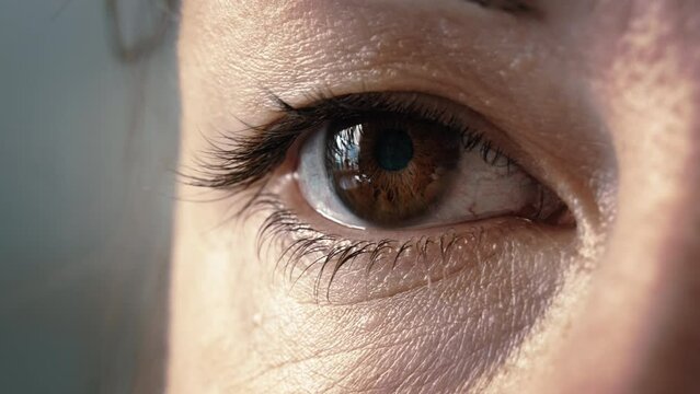 woman eye looks out the window macro shot, female brown eye, middle-aged woman's eye close-up, cinematic