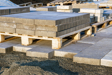 paving slabs made of artificial stone lie on pallets, preparing the base and providing drainage for...