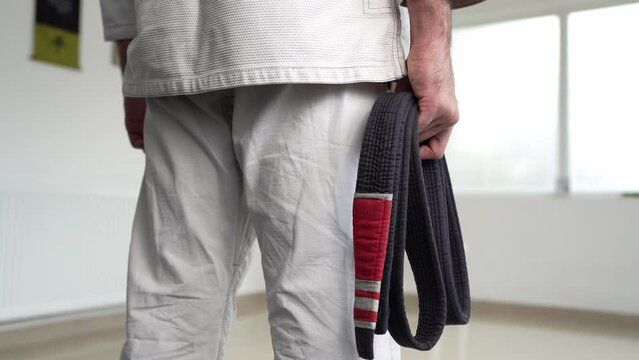 unknown caucasian man hold brazilian jiu jitsu bjj black belt