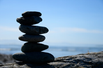A silhouette image of several stacked Zen-like rocks showing balance and harmony. 
