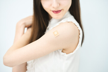 ワクチン接種のパッチが貼られた女性の腕