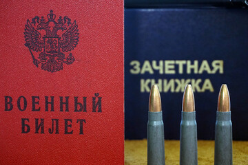 Russian military ID in front of Russian passport and three bullets in caliber 7.62x39mm. It...