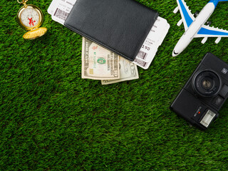 Travel planning, air travel. On the green lawn, travel items - money, tickets, documents, a camera, a toy airplane. Vacation, vacation, travel, tourism, adventure, business travel.
