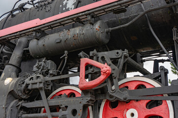 Train drive mechanism and red wheels of an old soviet steam locomotive.