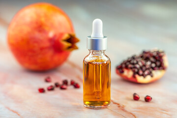 Pomegranate oil in a cosmetic bottle with a pipette. Natural cosmetics and face care.