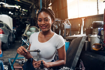 Fototapeta na wymiar Portrait of woman auto mechanic working at car repair shop with looking at camera.