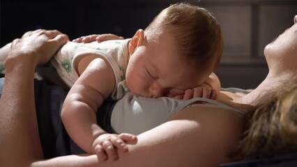 A tired mother sleeping together with his baby son on her chest in bedroom. Family bonding. Motherhood