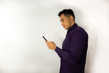 Hombre usando camisa morada mirando celular - obrazy, fototapety, plakaty