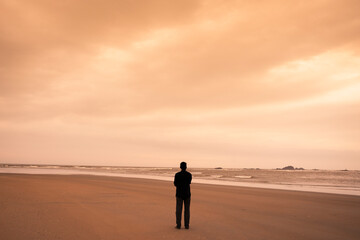 a young man spending time alone on the beach 