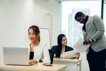 Cheerful male businesswoman entrepreneur professional working on laptop while sitting at office desk
