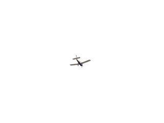 Small ultralight airplane with overhead wing and single propeller flying in sunset sky.