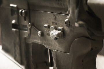 Close-up shot of selective fire of khaki camouflage M4 assault rifle, to be adjusted to fire in...