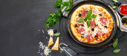Freshly baked pepperoni pizza on dark background.