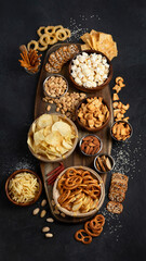 Fototapeta premium Assortment of salty snacks on dark background.