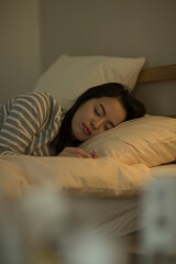 ベッドで眠る若い女性