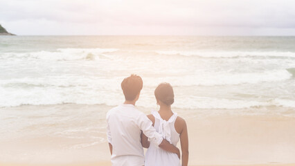 Happy young couple wearing white dress on the beach on holidays, travel, romantic, wedding concept