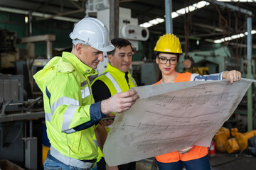 Team of male engineer and woman engineer worker working with factory building blueprint in the industry factory. Group of engineer worker discus with blueprint at work in the factory