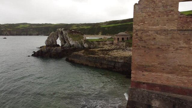Porth Wen aerial view abandoned Victorian industrial brickwork factory remains on Anglesey eroded coastline