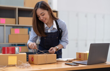 Young small business owner packing deliveries in modern office and storage space