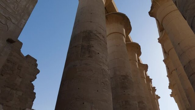 Famous Karnak Temple Colonnade, Luxor, Egypt. Carved hieroglyphs on pillars and ancient statues 