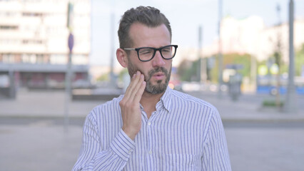 Outdoor Portrait of Young Adult Man with Toothache