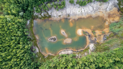 Blue lakes from above. Lakes in green forest in evening sunlight aerial drone view. Scenic summer background. Picturesque lakeside with forest. High quality photo. High quality photo