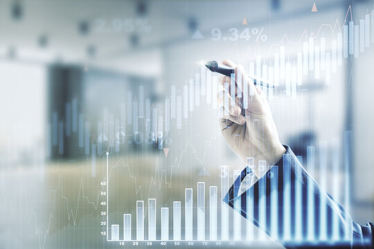 Multi exposure of trader hand with pen working with virtual abstract financial graph interface on blurred office background, financial and trading concept