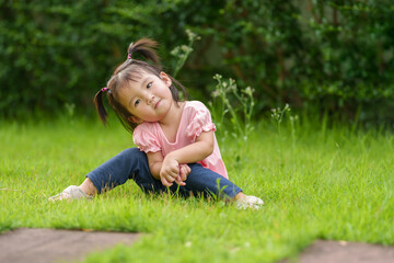 happy toddler girl sitting in field