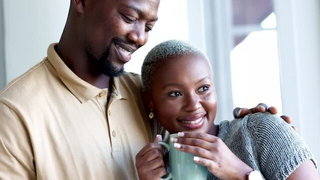 Happy couple, morning coffee and hug to show love and care while looking out hotel, apartment or bedroom window on honeymoon vacation. Happy black man and woman showing commitment and romance