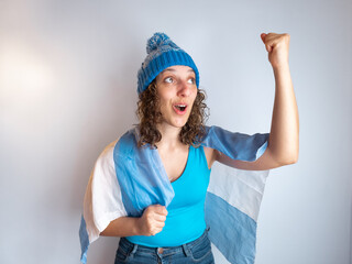 Argentina fan woman shouting goal with a national flag and wearing a light blue and white hat © SOPhI