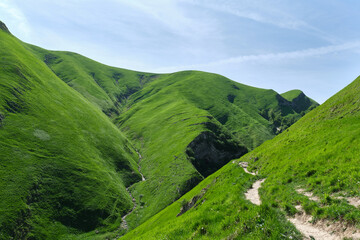 Cueva de Arpea, beautiful cave surrounded by large mountains covered with grass on the border between Spain and France