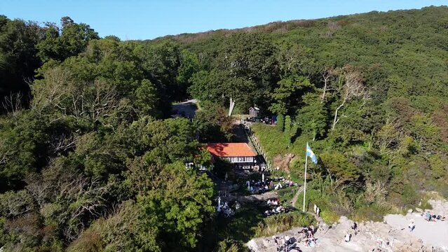 Ransvik Havsveranda restaurant at Molle, Sweden. A small rocky beach is seen with a swedish flag hanging from the pole.