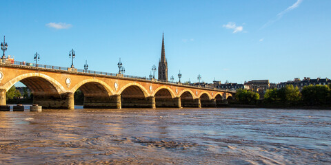 Pont de Pierre stone bridge with St Michel cathedral in Bordeaux city France