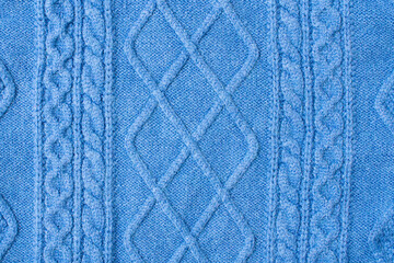 Blue warm knitted sweater with a pattern.Blue woolen sweater, knitted sweater texture, knitted background.