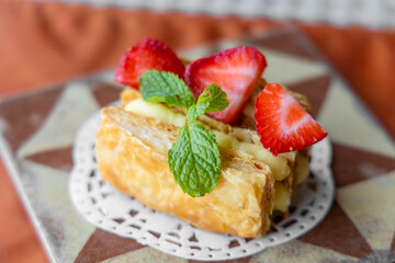 Slice of Napoleon cake with strawberry in restaurant