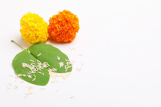 Indian Festival Dussehra, showing golden leaf (Piliostigma racemosum) and marigold flowers on white background.